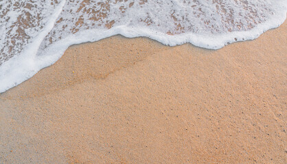 Fototapeta na wymiar white waves on the sand beach