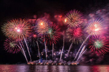 Amazing Colorful Fireworks exploding for Celebration from the big boat over the sea, celebration...