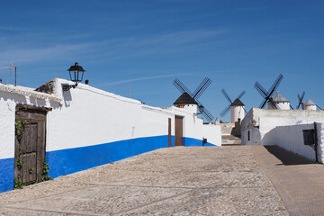 typical country street of campo de criptana with windmills in the background