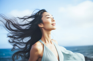 Young woman with eyes closed enjoying her freedom by the sea coast
