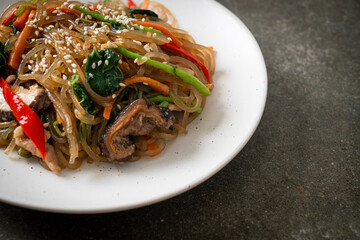 japchae or stir-fried Korean vermicelli noodles with vegetables and pork topped with white sesame