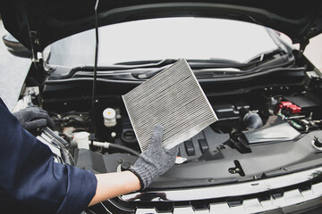 Auto mechanic holding old car air filter pollution to checking cleaning and replacing new for fix...