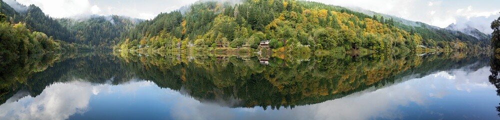 Panorama of the early morning reflections in the Umpqua River at the county park in Scottsburg, Oregon, USA