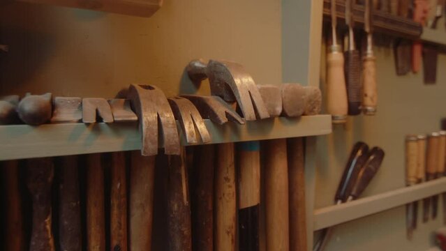 Close-up shot of hammers and mallets on the rack with woodworking hand tools in carpentry workshop