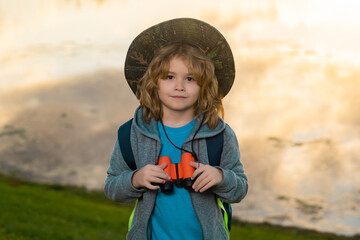 Traveler tourist kid. Travel and adventure concept. Little child boy tourist explorer with binoculars on nature. Discovery, exploring and education.