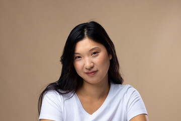 Portrait of asian woman wearing natural makeup and white t-shirt on beige background