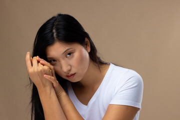 Portrait of asian woman wearing natural makeup and white t-shirt on beige background