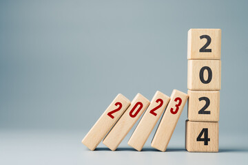 2023 domino effect ends at the 2024 stack wood cubes, new year solutions to stop the impact of 2023 finance, economic recession