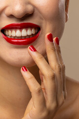 Naklejka premium Asian woman wearing red lipstick and nail polish on beige background