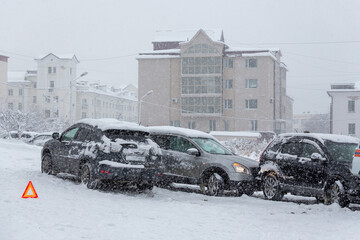 Car accident on a city street. Several cars crashed on a slippery snow-covered road. Difficult road...