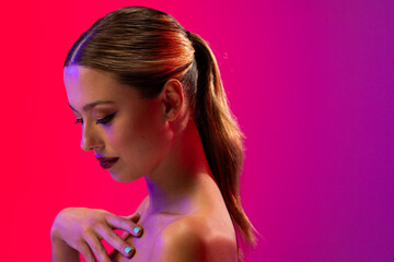 Caucasian woman wearing red lipstick and blue nail polish on purple background, copy space