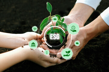 Businessman and little kid growing or nurturing plant together on fertile soil with eco friendly...