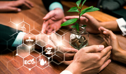 ESG business partner join hand around plant grown in money saving jar with digital eco technology...