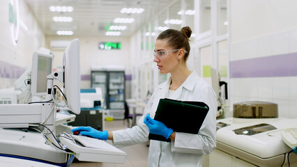 A female scientist controls the operation of devices for laboratory research. Modern laboratory technologies. Medical research centrifuge.