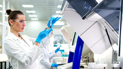 A medical research laboratory with a diverse team of biochemical scientists working with computers...