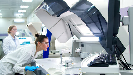A medical worker works in a hospital laboratory using an automatic biochemical analyzer. Concept of new medical technologies and modern research.