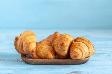 Fresh croissants on wooden background.