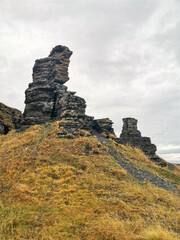 Two brothers rocks near Cape Zemlyanoi on the Kola Peninsula. Natural weathering pillars. The rocky coast of the Barents Sea. The ancient sanctuary of the Sami. Arctic Russia.