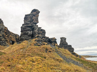 Two brothers rocks near Cape Zemlyanoi on the Kola Peninsula. Natural weathering pillars. The rocky coast of the Barents Sea. The ancient sanctuary of the Sami. Arctic Russia.