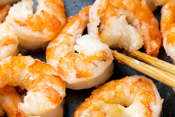 えびをフライパンで炒める調理シーン(片栗粉をまぶして)のアップ。
