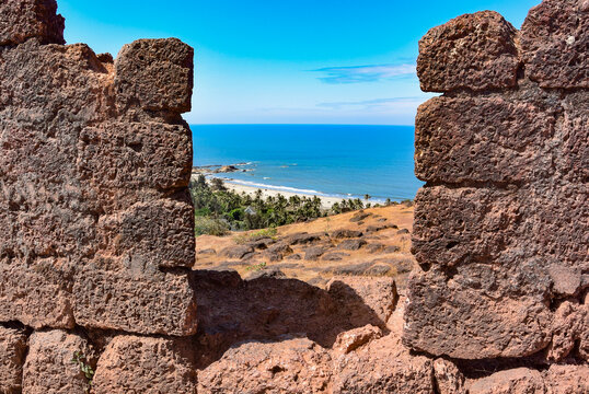 Fortress tower in Fort Chapora. In the background is a view of the beaches of Anjuna and Vagator in the northern part of Goa. The fort rises high above the Chapora River, India. Indian Ocean.