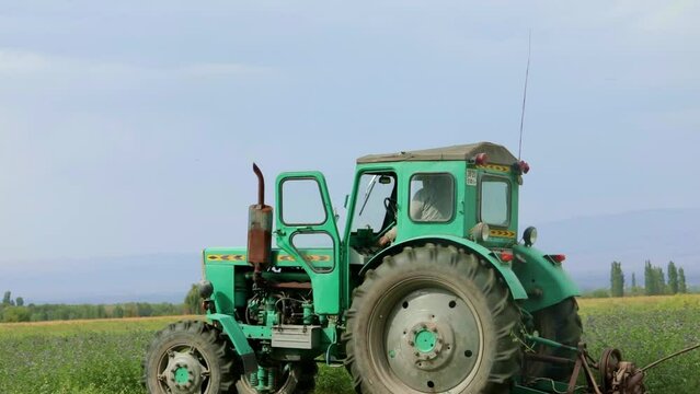 green tractor rides across the field	