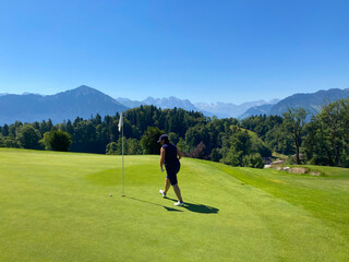 Golfer on Putting Green with Mountain View in a Sunny Summer Day in Burgenstock, Nidwalden,...