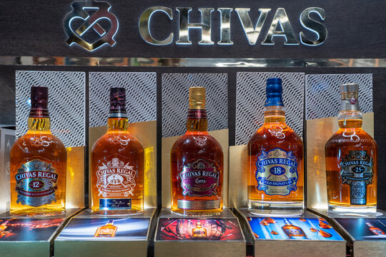 Bottles of Chivas Regal scotch whisky on a shelf in duty free shop airport in Muscat, Oman