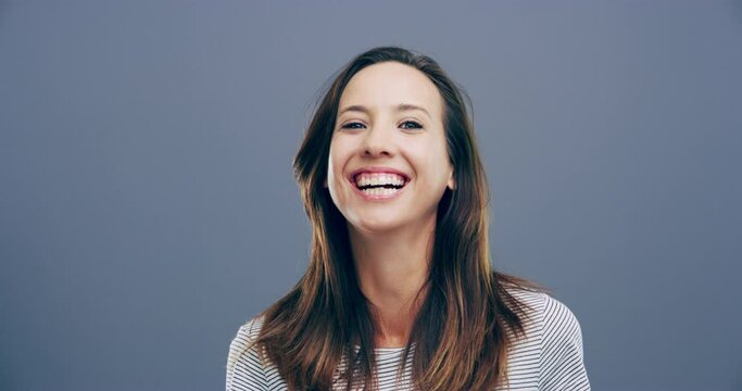Face, happy or woman laughing at joke or crazy comedy in studio isolated on gray background. Funny, excited model or silly female person with freedom, goofy smile or joy to relax alone with humor