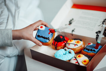 Assortment of halloween monsters donuts with funny faces in box at home interior