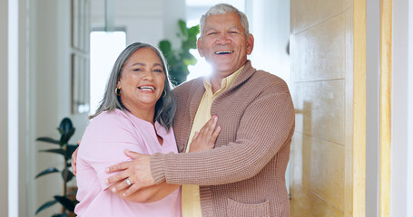 Portrait, love and smile with a senior couple in their retirement home together for friendly welcome. Happy, hug or embrace with an elderly man and woman in the doorway entrance to their apartment