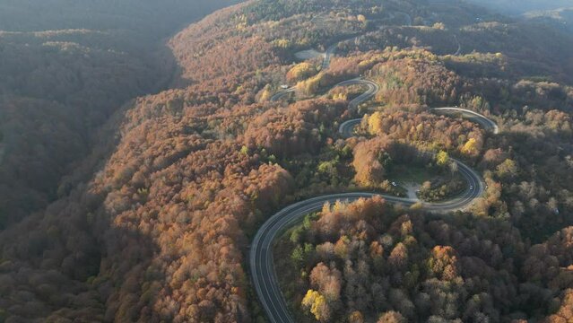 Curvy mountain roads in autumn. Vehicles in motion on winding mountain roads. 