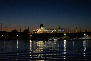 Fototapeta na wymiar Nave al Porto di sera