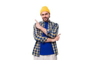 young handsome brunette man with a beard and mustache in a shirt and hat tells his idea