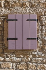 Picture of an old window with closed brown shutters