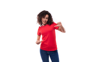 young slim leader woman with shoulder-length black curly hair is dressed in a red basic t-shirt with space for identity printing