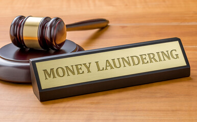 A gavel and a name plate with the engraving Money laundering