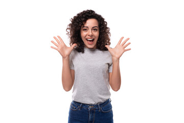 young surprised pretty brunette curly caucasian lady in casual jeans on white background with copy space