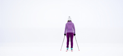 Woman cross country skiing. The silhouette of a skier goes into the distance skiing on snow against a white landscape background. with copy space