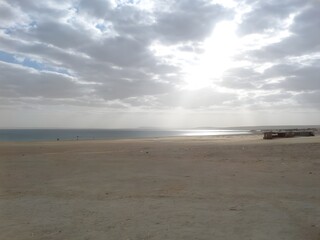 beach at sunset with cloudy sky and sunlight 