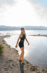Fototapeta na wymiar sporty girl at the beach, girl at the lake, jumping girl