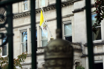 The flag of the Vatican, seen through the gates of the Vatican&rsquo;s embassy in the UK &ndash; officially the Apostolic Nunciature to Great Britain, in Wimbledon, London