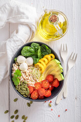 Delicious salad with avocado, cheese, tomatoes and groats.