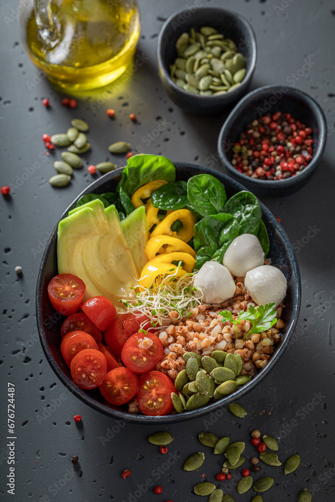 Wall mural Fresh salad with olive oil, vegetables and buckwheat groats.