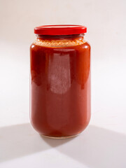 tomato sauce in glass jar on a white background