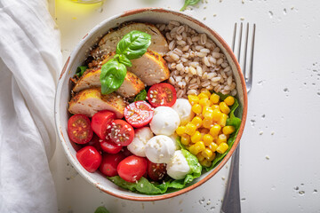 Fresh Caesar salad with tomatoes, pearl barley and corn.