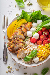 Healthy Caesar salad with tomatoes, pearl barley and corn.