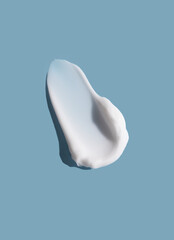 White cosmetic smear of cream texture on a blue background. Skin care.