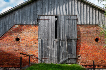 Fototapeta na wymiar Abandoned Barn. Weathered and worn red barn on an abandoned farm. Latvia.