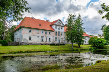 Fototapeta na wymiar Back view of the Pope manor through the pond. Latvia, Baltic.
